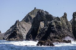 100% jagged rocks all around the foreshores. A lighthouse with fog horn visible on the top.